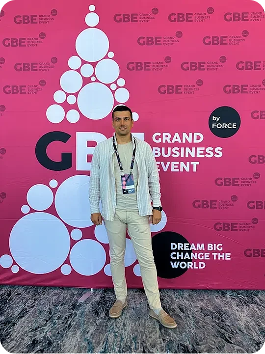 Представитель Webdelo на фоне баннера Grand Business Event 2024